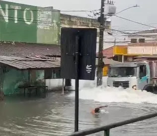 Homem nada em ponto de alagamento em João Pessoa e quase é atropelado por caminhão