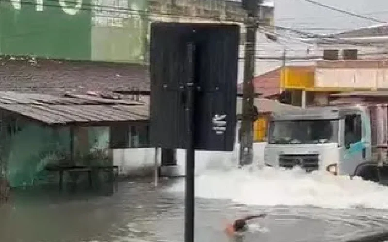 Homem nada em ponto de alagamento em João Pessoa e quase é atropelado por caminhão